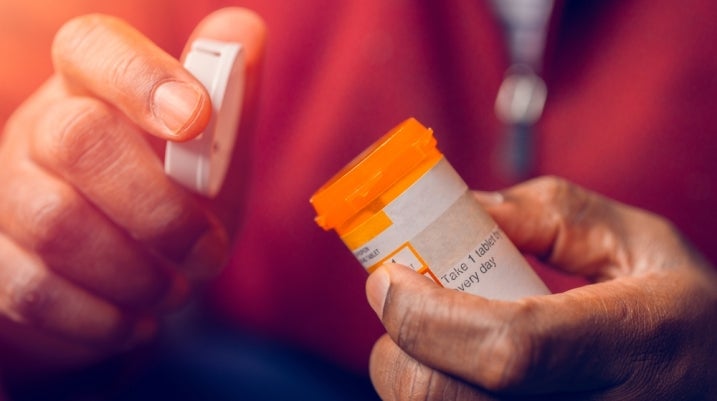Man opening pill bottle