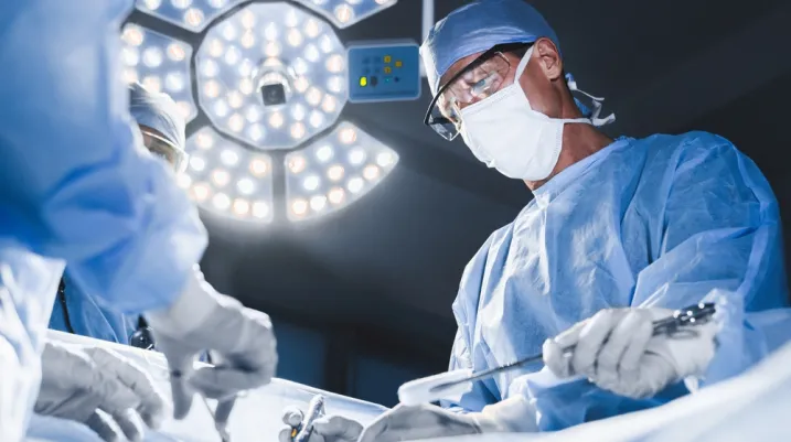 Group of surgeons at operation in operating room at hospital. Surgery, medicine and people concept. Medical case, urgent treatment, microsurgery concept
