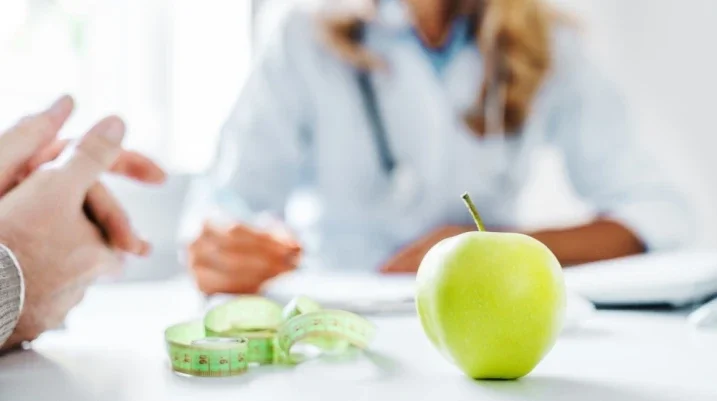 health concept showing people with apple, measuring tape and journal