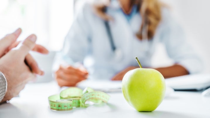 health concept showing people with apple, measuring tape and journal