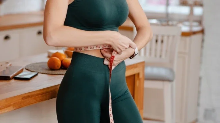 lady with a measuring tape in workout clothing