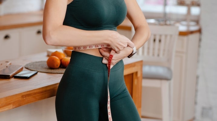 lady with a measuring tape in workout clothing