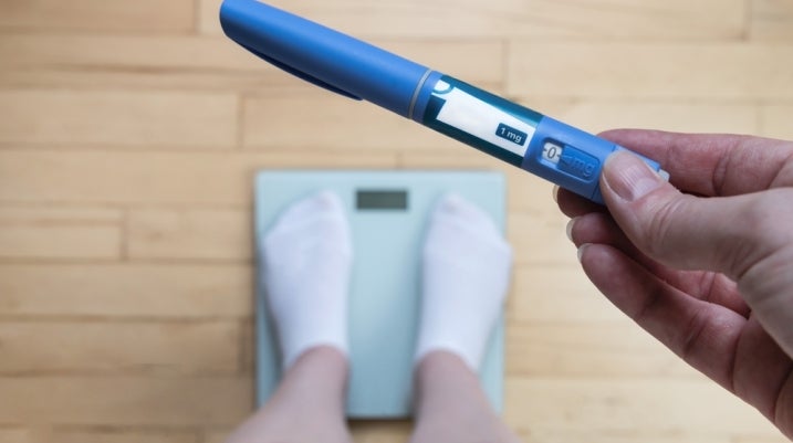 standing on a scale with a weight loss drug
