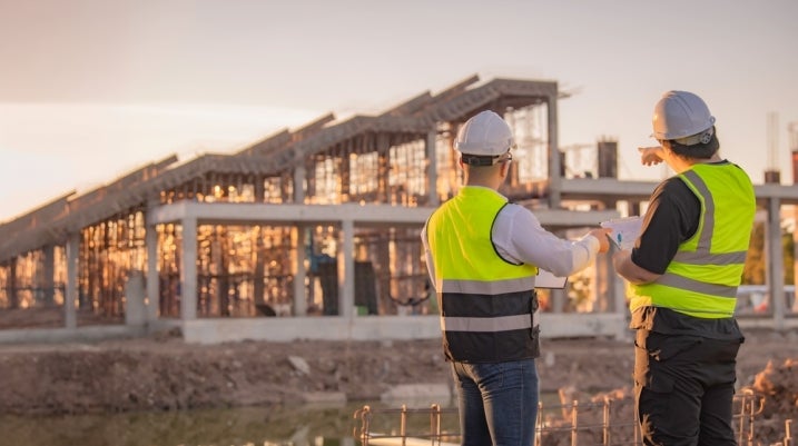 Construction worker helping another worker