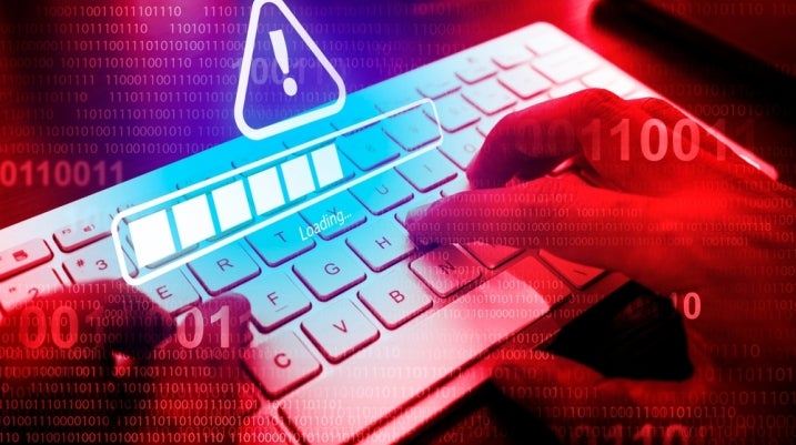 person typing on computer with a scam warning
