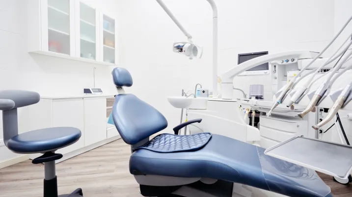 Dental equipment in dentist office in new modern stomatological clinic room. Background of dental chair and accessories used by dentists in blue and white.