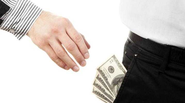 Overtime and Underpaid: Bankers Feeling the Same Pain as Fast-Food Workers - A hand reaching into a person's pocket to get the money. 
