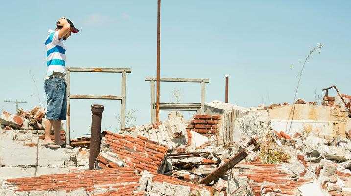 Man looking at collapse house