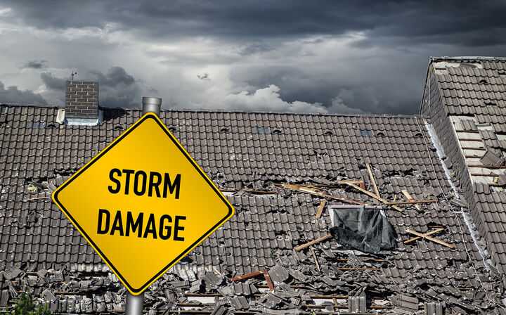 Wrecked Roof with Storm Damage Sign