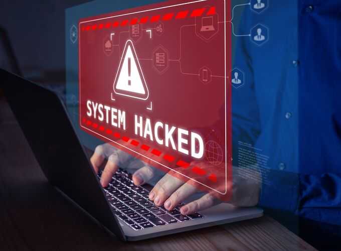 Cybersecurity alert with a holographic system hacked warning on laptop screen