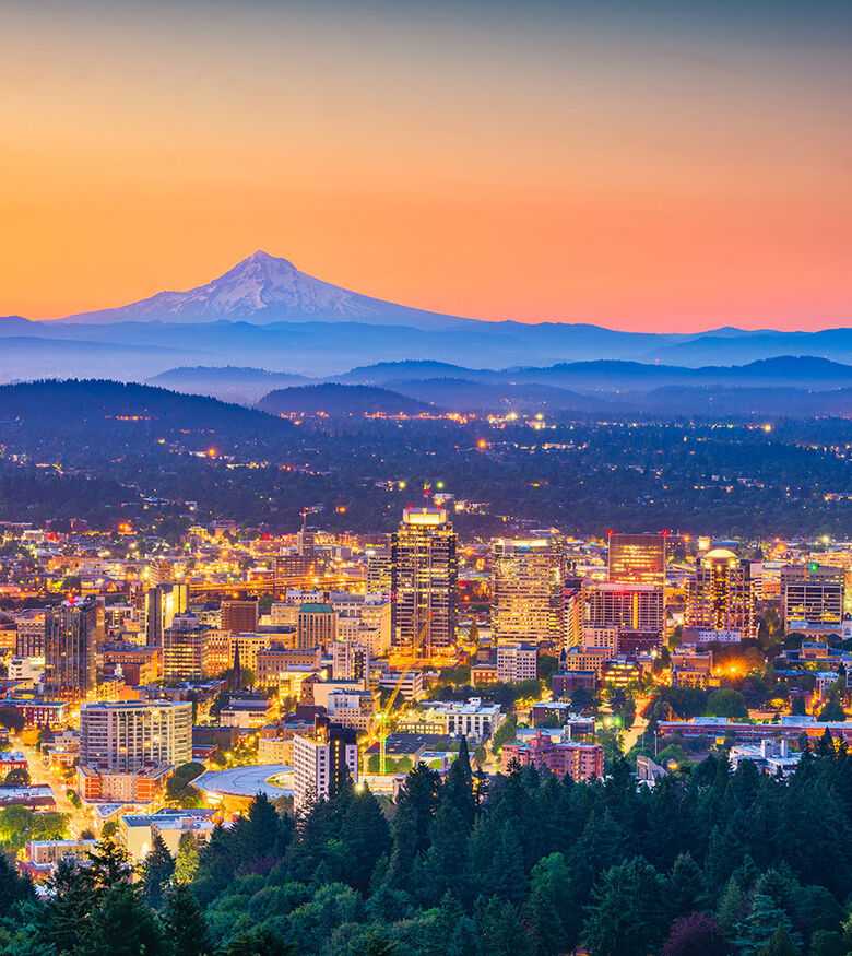 Portland city lights at dusk with Mount Hood in the background, a scenic hub for personal injury lawyers.
