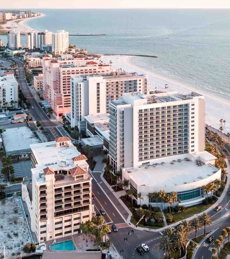 Clearwater beachfront aerial view showcasing bustling hotels and ocean, a key market for personal injury lawyers.