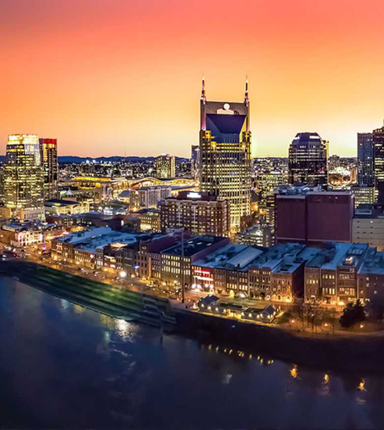 Nashville skyline at sunset reflecting in the river, a vibrant scene for personal injury lawyers.
