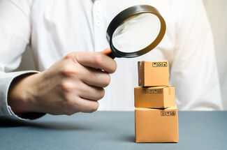 Product Liability Lawyers in Houston, TX - Man with magnifying glass looking at small boxes