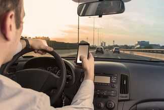 What Should I Know About Identity Theft Liability in NYC - person driving with their phone
