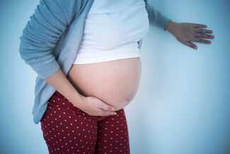 Pregnant woman holing stomach
