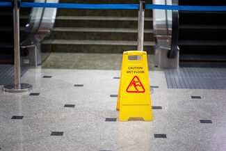 Wet floor sign in front of escalator